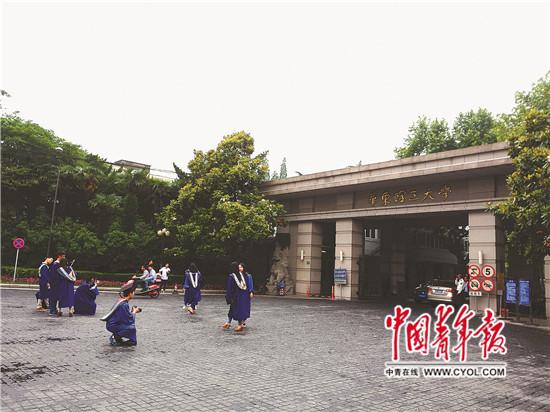 5月29日,穿着蓝色学位服的硕士生在华东理工大学徐汇校区门口拍照。中国青年报·中青在线记者 李雅娟/摄