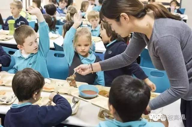 　上海英国学校的孩子在吃午餐，吃完了举手问老师要