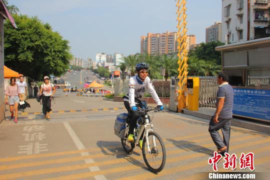 近日，骑行进入江西理工大学校园的周琦桓。　王文贤 摄