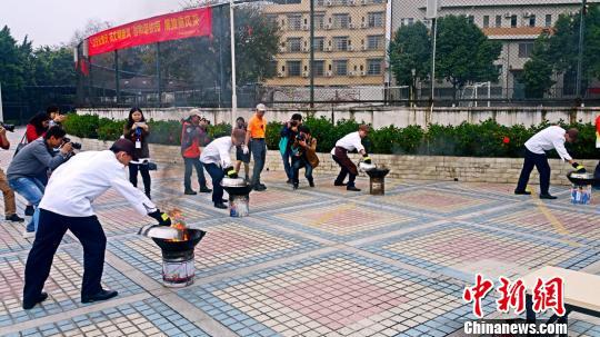 生命安全教育成广州中小学生开学第一课。图为广州中学生在开学第一课上学习油锅灭火。　许青青 摄