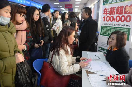 资料图:2月15日,山西太原,春节后首场高校毕业生招聘会开场,图为众多求职者被一家公司的高薪待遇吸引。韦亮 摄