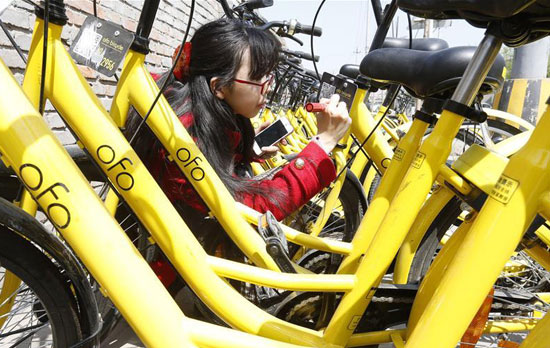 李冬雨在北京街头为被划掉多位数字的共享单车补牌。新华社记者 张玉薇/摄