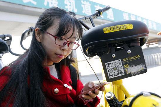 李冬雨在北京街头为被划掉多位数字的共享单车补牌。新华社记者 张玉薇/摄