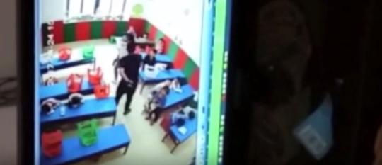 　　图为施暴者王某某追打保护孩子的幼儿园女教师 网络视频截图 摄