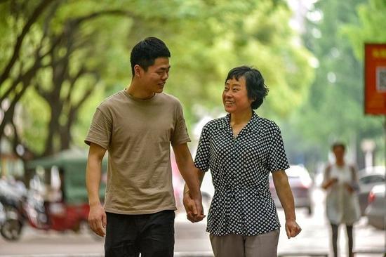 　　吴步晨带着失明的母亲在校园内散步。陈飞摄