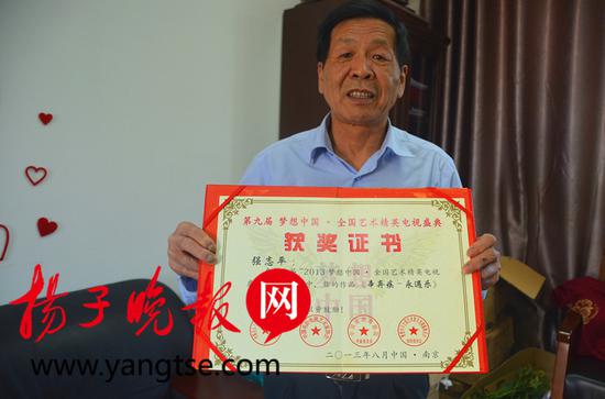 付出终有回报，强志平拿着获奖证书 高晓平 摄