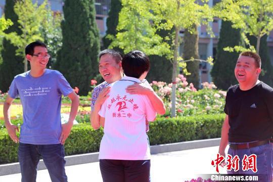 图为衡水二中校长秦海地与学生拥抱。 衡水二中提供 摄