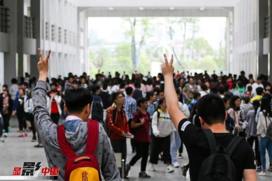 6月7日，在江苏省扬州市仙城中学高考考点，两名考生摆出胜利手势进入考场。当日，2017年高考拉开帷幕，全国高考报名考生共940万人。新华社发（郁兴摄）
