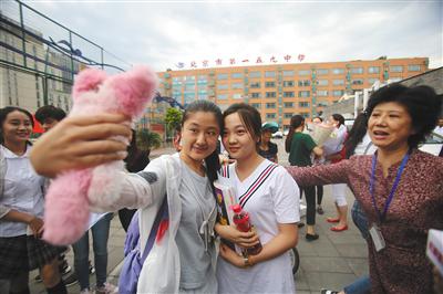 昨日，西城区一五九中学考点，考试结束后，童星林妙可与同学在校门前合影留念。新京报记者 王飞 摄