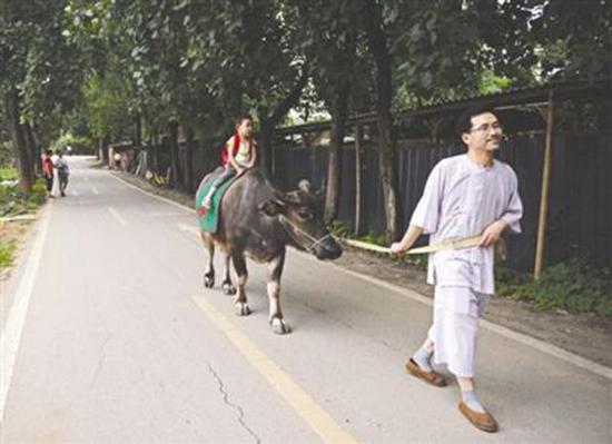 李里用牛送三岁儿子上幼儿园从去年冬天就开始了。成都商报 图