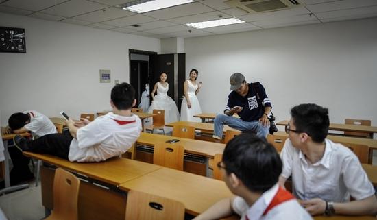 图为6月11日，中国科技大学少年班学院创新试点二班，女生换上婚纱走进教室，准备拍摄毕业合影。