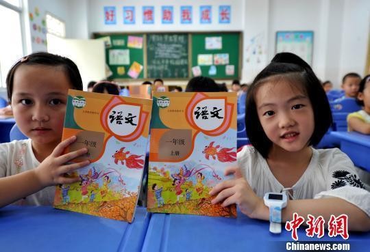 资料图：小学新生展示语文教材。张斌 摄