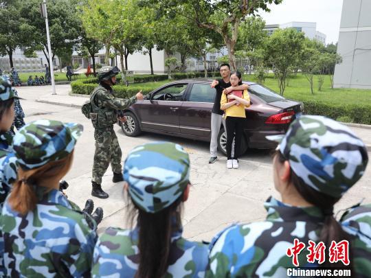     上海高校军训首次新增反劫持演练。图为6日现场武警教官为参训学生演示反劫持要领。　王知洲　摄