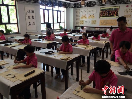 在新疆喀什地区疏附县托克扎克镇中心小学，维族学生们在练习写汉字书法。　蔡敏婕　摄