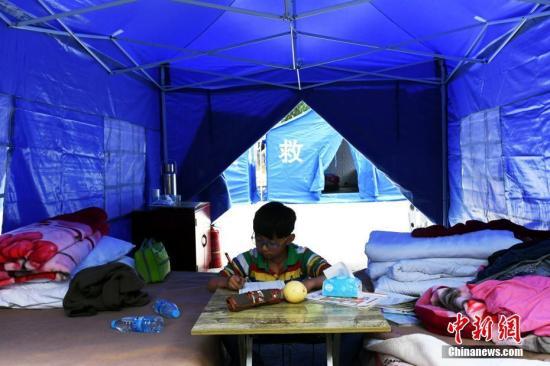 8月11日，四川九寨沟“8.8”地震震源中心附近的漳扎镇漳扎村二组安置点，在帐篷里学习的小朋友。 中新社记者 安源 摄