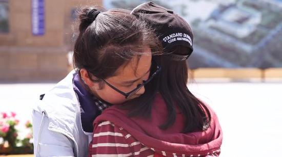 高三学生卡米拉和北大志愿者戴儡玥依依不舍告别