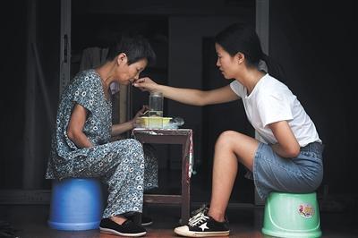9月9日，江西南昌，赵金凤在出租房里陪母亲吃午饭。图片来源：新京报
