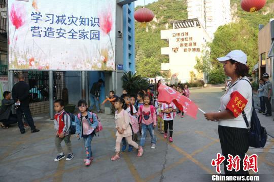 图为学生放学时，罗杏琳在门口指挥学生秩序　林馨　摄