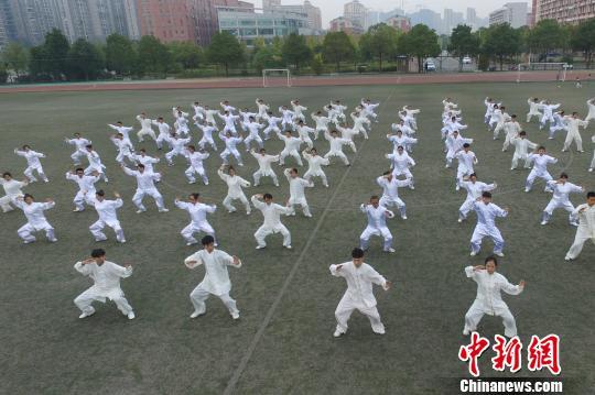 参加竞赛的大学生在足球场集体打太极弘扬中医文化。　杨华峰 摄
