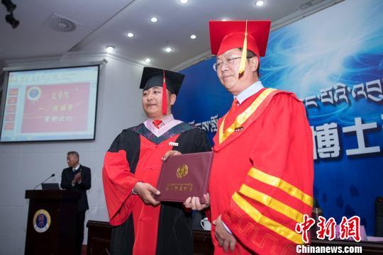 图为西藏大学校长纪建洲(右一)为学位获得者颁发博士学位证书。　何蓬磊 摄