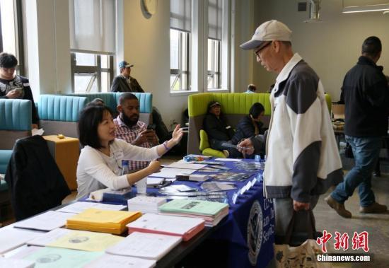 资料图：美国移民局官员在为民众提供多种语言的入籍服务。 中新社记者 刘丹 摄