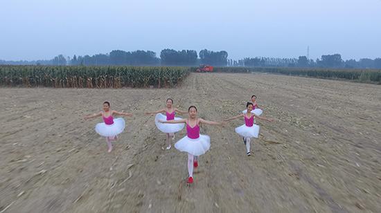 端村学校芭蕾舞班的孩子们在田野里玩耍。