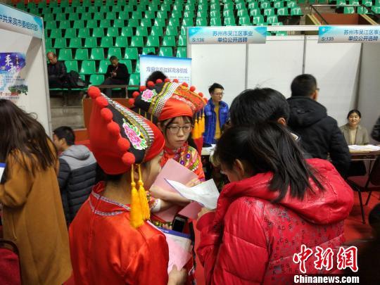 图为用人单位身着特色服饰为求职者答疑。　项飞 摄