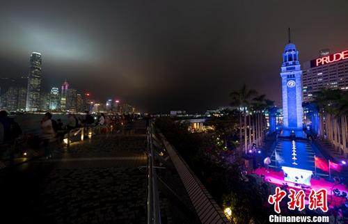 资料图片:香港尖沙咀钟楼亮灯。图为蓝色钟楼与维多利亚港的迷人夜景交相辉映。中新社记者 张炜 摄