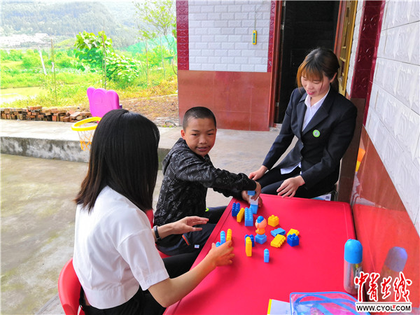 曾口镇中心小学的老师指导冯奉林搭积木。中国青年报·中青在线见习记者 张胶/摄