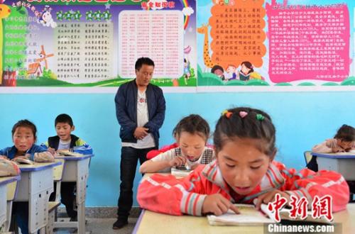 5月24日，切强加正在给小学一年级的学生上藏文课。中新社记者 鲁丹阳 摄