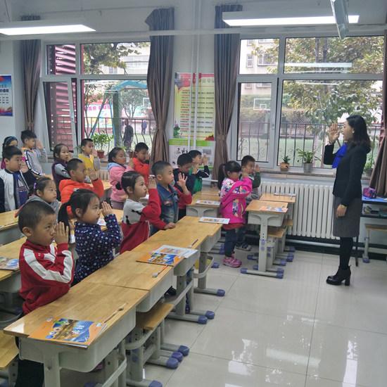 济南市第十四中学老师教一年级学生做阳光亮眼操。(济南市第十四中学供图)