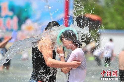 资料图:两名游客遭到泼水“袭击”。 中新社记者 刘冉阳 摄