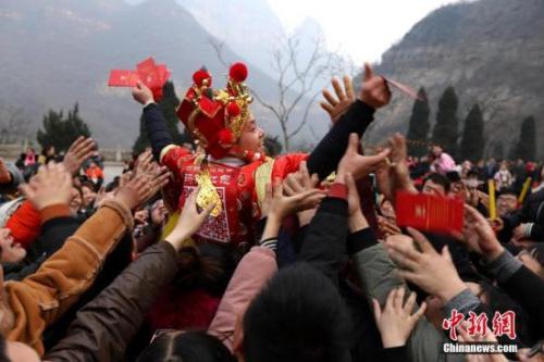 资料图:“财神”向游客派发现金红包。 王中举 摄