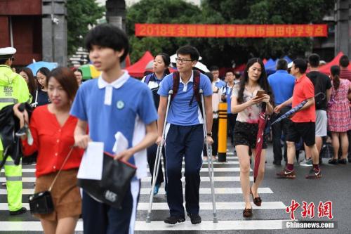 资料图：2018年6月7日，2018年高考进入第一天。图为福田中学考场外，一位高考生带伤上考场。中新社记者 陈文 摄