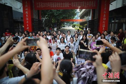 资料图:走出考场的考生在考点前合影。泱波 摄