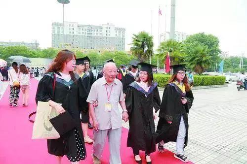 杨文明老人和受助学生一起走毕业红毯