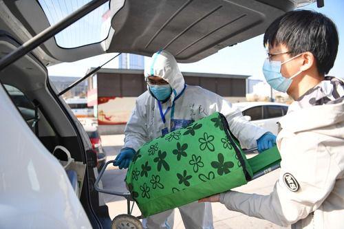 1月18日，在石家庄站西广场，范越甲帮助一名返石大学生把行李装进后备箱。新华社记者 朱旭东 摄