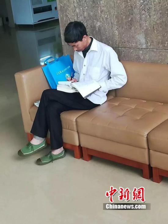 学校学生拍下的园丁大叔在图书馆休息区学习的画面。云南中医学院提供
