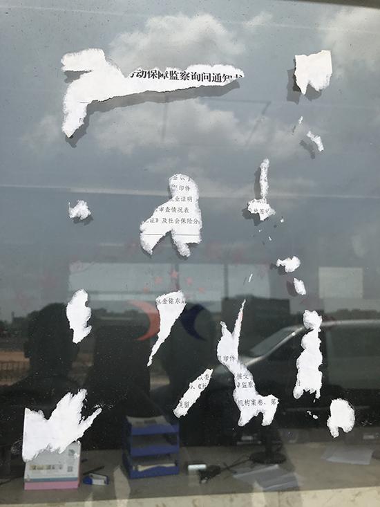 广东缘遇公司玻璃门上被撕去的劳动保障监察询问通知书。