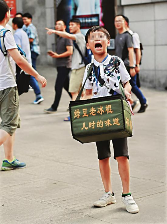 11日下午5时，汉口江汉路步行街，9岁的小学生杨祝捷正冒着酷暑卖冰棍。长江日报记者 金思柳 摄