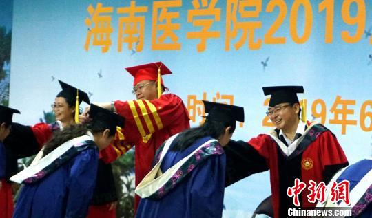 毕业生们接受校长、导师拨穗正冠。 黄艺 摄