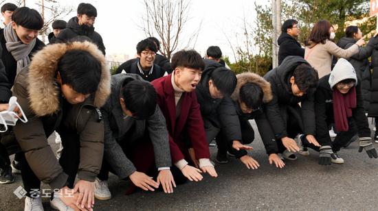 韩国一高中前,后辈为参加高考的前辈行大礼。(韩媒《中度日报》)