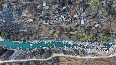 2月26日，大石头组建在大岩山峭壁之下的斜坡面。因为处于枯水期，加上上游水电站截水发电，所以牛栏江水势较小，但往返两岸依旧需要溜索过江。陈杰/摄