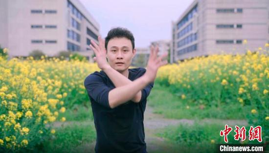 浙江工商大学教师屠锋锋在校园油菜花田起舞。校方提供