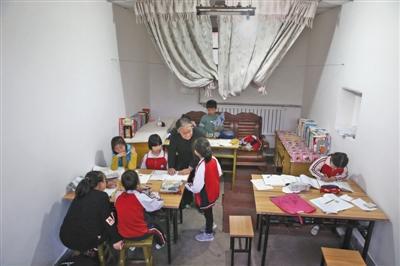 严敏文正在指导孩子们学习功课。