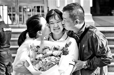 陈经纶中学考点外，爸爸妈妈手持鲜花迎接女儿