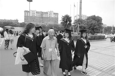 杨文明老人和江苏大学受助学生一起走毕业红毯。