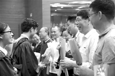 福州大学毕业典礼上,毕业生向老师献花。