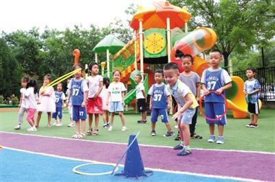  8月12日，北京市昌平区天骄幼儿园操场，小朋友在老师的带领下玩“套环”游戏。新京报记者 王贵彬 实习生 陈婉婷 摄