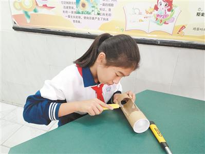 郑家尔在制作贴对联神器。